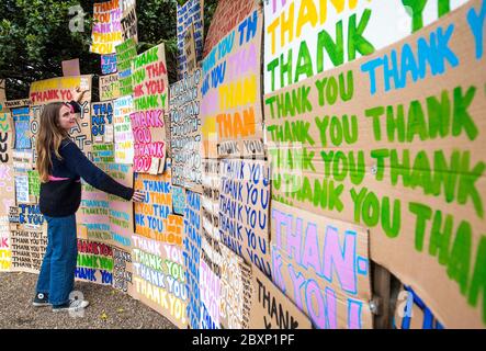 Hermine Wilson hilft bei der Installation eines neuen Kunstwerks im Jupiter Artland, Edinburgh, das als Hommage an das NHS mit dem Titel 'A Thousand Thank Yous' entstand, das ursprünglich vom verstorbenen Allan Kaprow entworfen wurde und aus bunt gemalten Botschaften auf Karton besteht und von dem Londoner Künstler Peter Liversidge ferngesteuert inszeniert wurde. Stockfoto