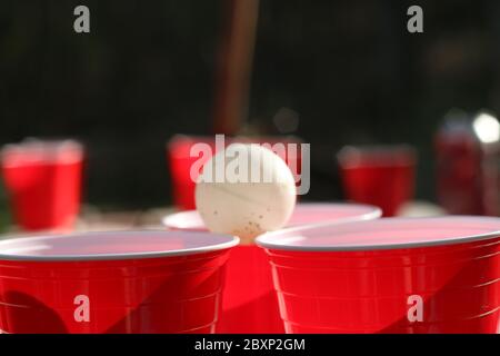 Rote Party Cups Themen Hintergrundvorlage. Weißer Hintergrund. Alkoholbehälter auf der Seite. Menschen tanzen Hände hoch in der Luft. Leerer leerer Kopierplatz Stockfoto