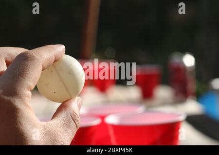 Rote Party Cups Themen Hintergrundvorlage. Weißer Hintergrund. Alkoholbehälter auf der Seite. Menschen tanzen Hände hoch in der Luft. Leerer leerer Kopierplatz Stockfoto