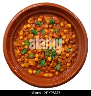 Chana Masala mit Süßkartoffeln. Würziges, vegetarisches Kichererbsencurry in einem Steingut-Gericht. Isoliert auf weißem Hintergrund. Stockfoto