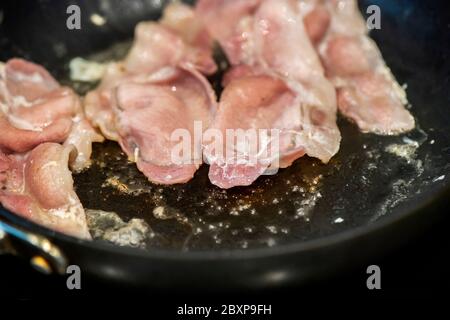 Fett wird als Back Bacon Pommes in einer Pfanne freigesetzt Stockfoto