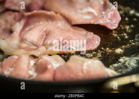 Fett wird als Back Bacon Pommes in einer Pfanne freigesetzt Stockfoto