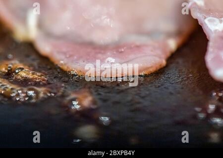 Fett wird als Back Bacon Pommes in einer Pfanne freigesetzt Stockfoto