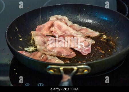 Fett wird als Back Bacon Pommes in einer Pfanne freigesetzt Stockfoto