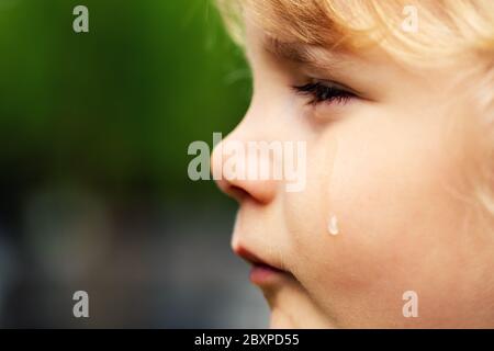 Weinendes trauriges Kind - kleines Mädchen Gesicht mit Träne auf der Wange. Konzept der Kinderrechte und Missbrauch Stockfoto