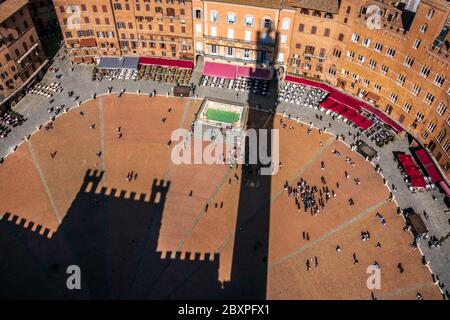 Der Rathauspalast von Siena, der von oben nach unten gedreht wurde, projizierte seine Schatten auf den berühmten historischen Platz von Campo Stockfoto