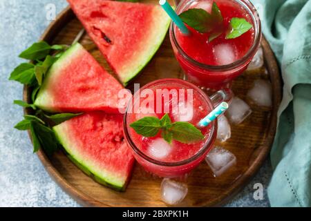 Kalte Wassermelone Smoothie. Sommer Wassermelone Getränk und Scheiben Wassermelone auf einem hellen Steintisch. Stockfoto