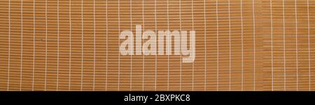 Panoramablick auf einen Rattanteppich. Gelbe Webstruktur. Nahaufnahme der Strohmatte als abstrakter Hintergrund. Stockfoto