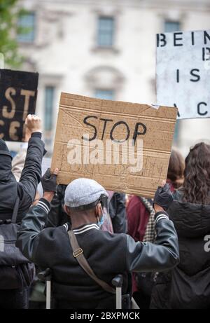 Mann, in einem Rollstuhl, hält ein Pappschild mit der Aufschrift "STOPPEN" auf dem Black Lives Matter UK Protest, Parliament Square, London, England UK Stockfoto