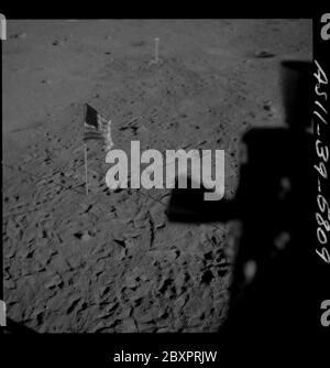 AS11-39-5809 - Apollo 11 - Apollo 11 Missionsbild - Schatten der Mondlandefähre und US-Flagge auf der Mondoberfläche; Umfang und Inhalt: Die Originaldatenbank beschreibt dies als: Beschreibung: Schatten der Mondlandefähre (LM) auf der Mondoberfläche. US-Flagge und Fernsehkamera sichtbar. Bild aus dem Inneren der LM nach der Landung auf der Tranquility Base während der Apollo 11 Mission. Original Film Magazin wurde mit Q. Film Typ: SO 3400 Panatomic-X Schwarz/Weiß aufgenommen mit einem 80mm Objektiv. Sonnenwinkel ist niedrig. Der ungefähre Neigungswinkel ist niedrig. Bild wurde verwendet, um eine Panoramaansicht von zu machen Stockfoto