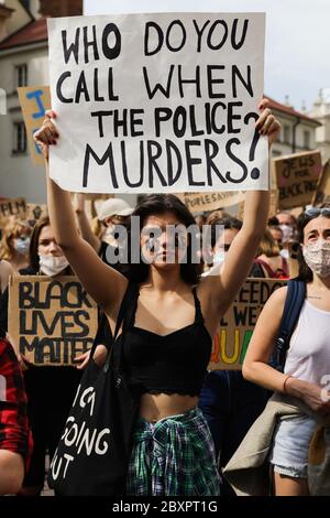 Eine junge Protesterin mit der Abkürzung 'ACAB' auf ihrem Gesicht hält ein Plakat mit dem Slogan 'wen nennst du, wenn die Polizei mordet'. Hun Stockfoto