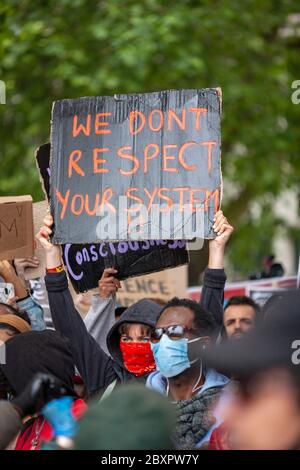 Frau, die einen Kapuzenpullover und eine Gesichtsmaske trägt, hält ein Schild am Protest der Black Lives Matter UK, Parliament Square, London, England, Großbritannien Stockfoto