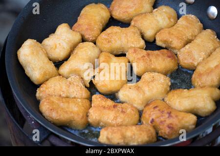 Gebratene Hähnchennuggets in der Pfanne mit heißem Öl. Stockfoto