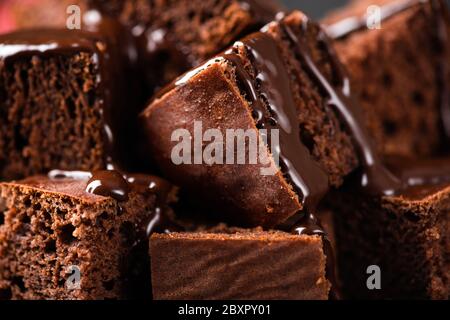 Schokoladenkuchen Quadrate mit Schokoladensauce. Nahaufnahme Ansicht Schokolade Brownie Textur Stockfoto