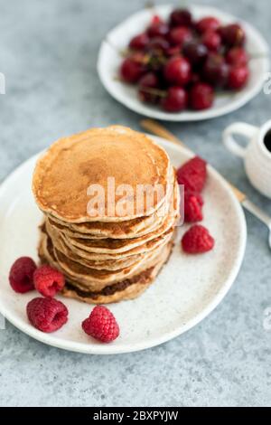 Haferpfannkuchen mit Beeren auf dem Teller. Gesunde vegane vegetarische Pfannkuchen, kalorienarme Pfannkuchen Stockfoto