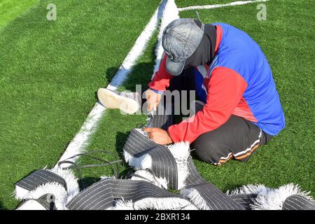 Fußballplatz Installation von Kunstrasen durch Techniker Stockfoto