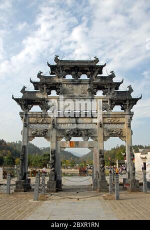 Die alte Stadt Xidi in der Provinz Anhui, China. Der Torbogen der Hu Wenguang Gedenkstätte in der Nähe des Eingangs zur Altstadt und des Ming Jing Sees Stockfoto