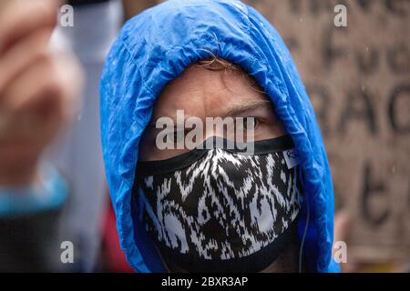Mann, der eine gemusterte Gesichtsmaske und blaue Kapuze trägt, beim Black Lives Matter UK Protest, Parliament Square, London, England, U Stockfoto