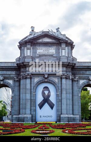 Madrid, Spanien - 7. Juni 2020: Puerta de Alcala oder Alcalá Tor. Banner mit schwarzem Band als Symbol der Trauer für diejenigen, die während der CO gestorben sind Stockfoto