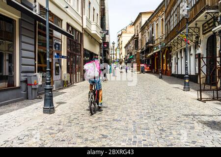Ein Food Panda-Kurier für die Lebensmittelzustellung auf dem Fahrrad in der Altstadt von Bukarest, Rumänien, 2020. Lebensmittellieferungen durch Fahrradkuriere aufgrund eines Coronavirus-Ausbruchs Stockfoto