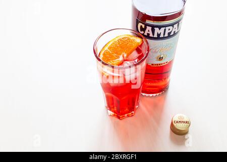 MOSKAU, RUSSLAND - 4. JUNI 2020: Kappe, Glas mit Cocktail und Flasche Campari Bitter auf dem Tisch. Campari ist ein italienischer Alkohollikör, der zu Davide C gehört Stockfoto