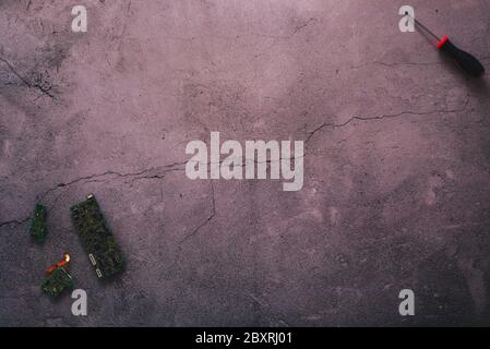 Flaches Einlegen einiger Mainboards und eines Schraubendrehers auf einem gesprungenen Betonhintergrund mit viel Kopierplatz Stockfoto