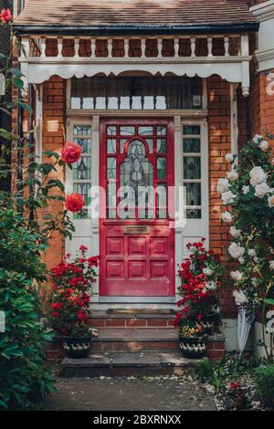 London, Großbritannien - 30. Mai 2020: Dunkelrosa Buntglas-Eingangstür eines traditionellen edwardianischen Hauses in London, selektiver Fokus. Edwardianische Häuser fördern si Stockfoto