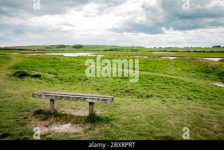 Bank mit Blick auf die South Downs, England. Die Hochwasserebenen von Cuckmere Haven im South Downs Nationalpark an der Südküste Englands. Stockfoto