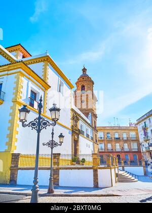 Die alte Straßenlaterne vor der historischen Santo Domingo Kirche mit erhaltenen mittelalterlichen Glockenturm, Cadiz, Spanien Stockfoto