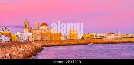 Panorama der Skyline von Cádiz bei violetter Dämmerung, die sich im Atlantik, Costa de la Luz, Spanien, widerspiegelt Stockfoto