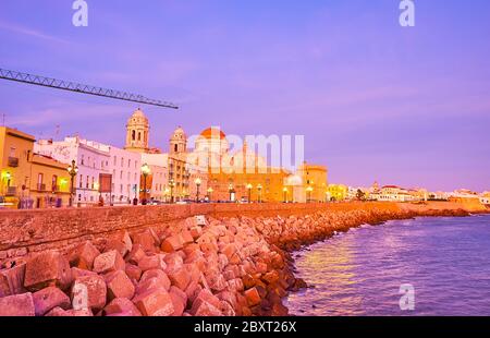 CADIZ, SPANIEN - 23. SEPTEMBER 2019: Die Dämmerung Skyline mit historischen Kathedrale, erhebt sich über den alten Häusern und historischen Festungsmauer, am 23. September i Stockfoto