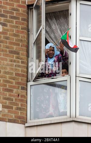 Eine Frau und ein Kind lehnen sich aus dem Fenster, um eine Flagge zu schwenken, um den Protest von Black Lives Matters auf der Vauxhall Bridge Road, London, 6. Juni 2020 zu unterstützen Stockfoto