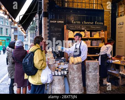 Neals Yard Dairy Outdoor-Ausstellung und Verkostung Markt Stall Englisch Käseladen Outdoor Stall & Kunden im Borough Market London Bridge Southwark London UK Stockfoto