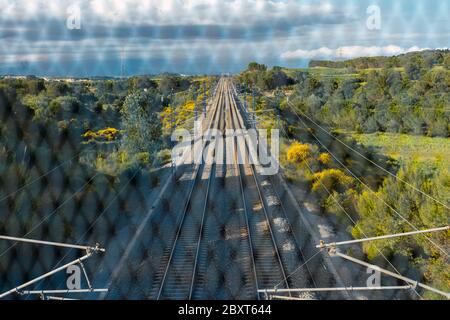 Zuggleise zwischen den Bergen, von der Brücke durch das Tor gesehen. Tiefe und Weg Konzept. Stockfoto