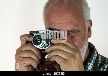 Ein Senior fotografiert mit seiner alten, antiken Analogkamera. Stockfoto