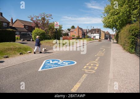 Danke NHS in blau gemalt außerhalb Cobham Schule geschlossen wegen Pandemie und soziale Distanz wegen Coronavirus, Menschen zu Fuß