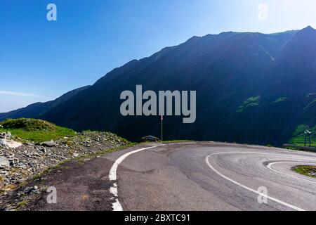 Bergstraße an einem sonnigen Morgen. Leere Autobahn bergauf durch Tal. Große europäische Reise im Sommer Konzept. Stockfoto