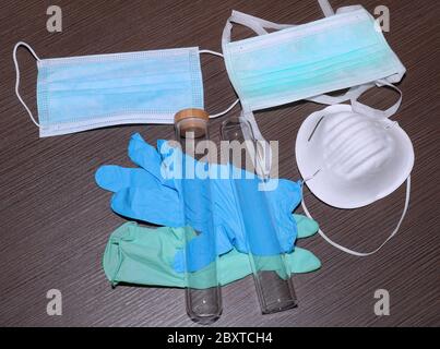 Medizinische Geräte mit verschiedenen Arten von Gesichtsmasken und Handschuhen, die im Labor mit Reagenzgläsern verwendet werden Stockfoto