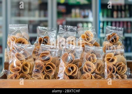 'Thong Muan' ist eine Art von Walzwaffel, ein traditionelles Dessert in Kunststoff-Rückenverpackung in lokalen Convenience-Store in Thailand Stockfoto