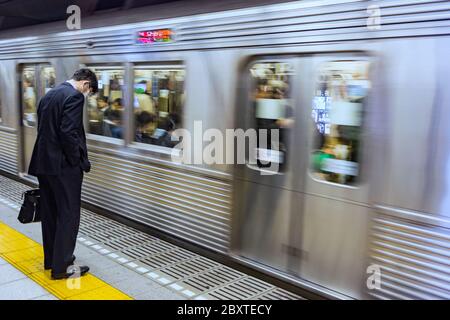 Tokio / Japan - 19. Oktober 2017: Müde Geschäftsmann wartet auf eine U-Bahn in Tokio, Japan Stockfoto