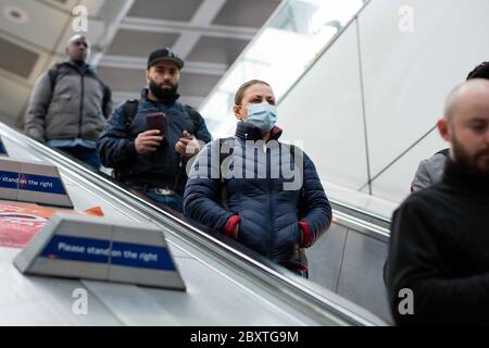 Ein Passagier betritt den Canning Town Station bereits mit einer Maske während der Hauptverkehrszeit am ersten Tag des Programms. TFL steuern die vorübergehende Verteilung von s Stockfoto