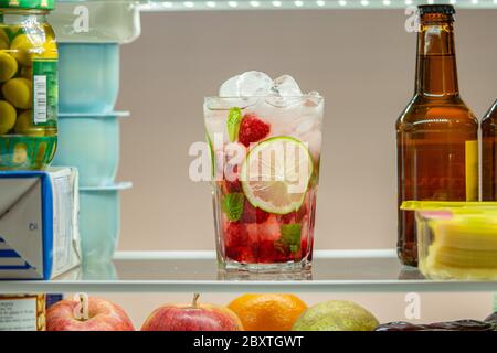 Cocktail aus Himbeer-Mojito im Kühlschrank. Nahaufnahme. Kaltes, frisches und veganes Getränk. Stockfoto
