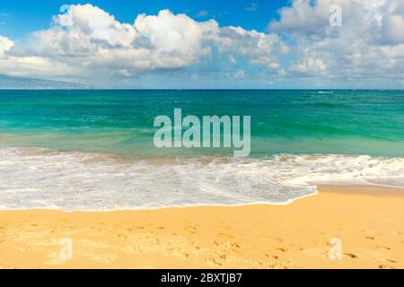 Ein Sandstrand mit Wolken auf der Hawaii Insel Maui. Stockfoto