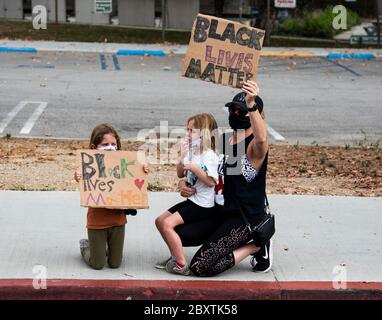 Eine Mutter mit ihren Kindern protestiert mit Schildern zu Ehren von George Floyd im Highland Park-Viertel von Los Angeles, Kalifornien Stockfoto