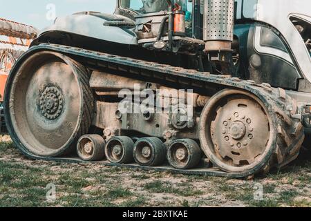 Traktor auf einem landwirtschaftlichen Feld aus der Nähe. Ein moderner neuer Raupentraktor ist sehr nah. Stockfoto