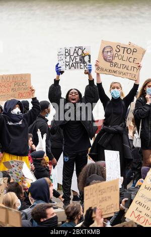 Demonstranten, die Schilder halten, stehen auf der Vauxhall Bridge während des Black Lives Matters Protests in London, 6. Juni 2020 Stockfoto
