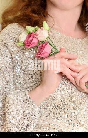 Junge Frau hält einen Strauß von eustoma Blumen. Schöne Hände und lange natürliche Nägel. Stockfoto