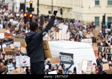 Ein schwarzer Mann hebt seine Faust über eine Menge Demonstranten in der Nähe der Vauxhall Bridge, während der Black Lives Matters-Proteste in London, 6. Juni 2020 Stockfoto