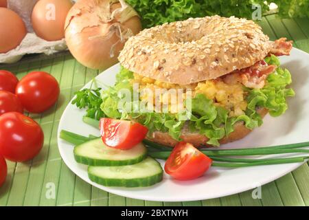 Bagel mit Rührei und Speck Stockfoto