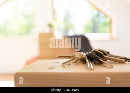 Verschieben. Pappkartons für den Umzug in ein neues, sauberes Zuhause. An einem sonnigen Tag durch ein Fenster im Dachgeschoss. Stockfoto